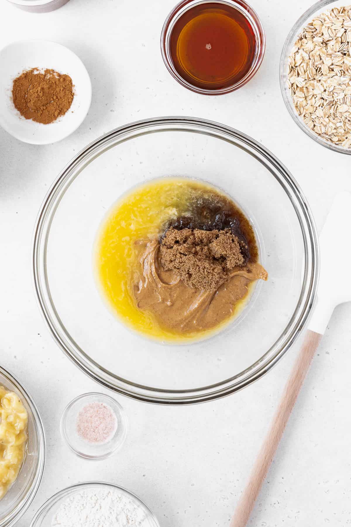 A mixing bowl with melted vegan butter, brown sugar, peanut butter, and maple syrup.