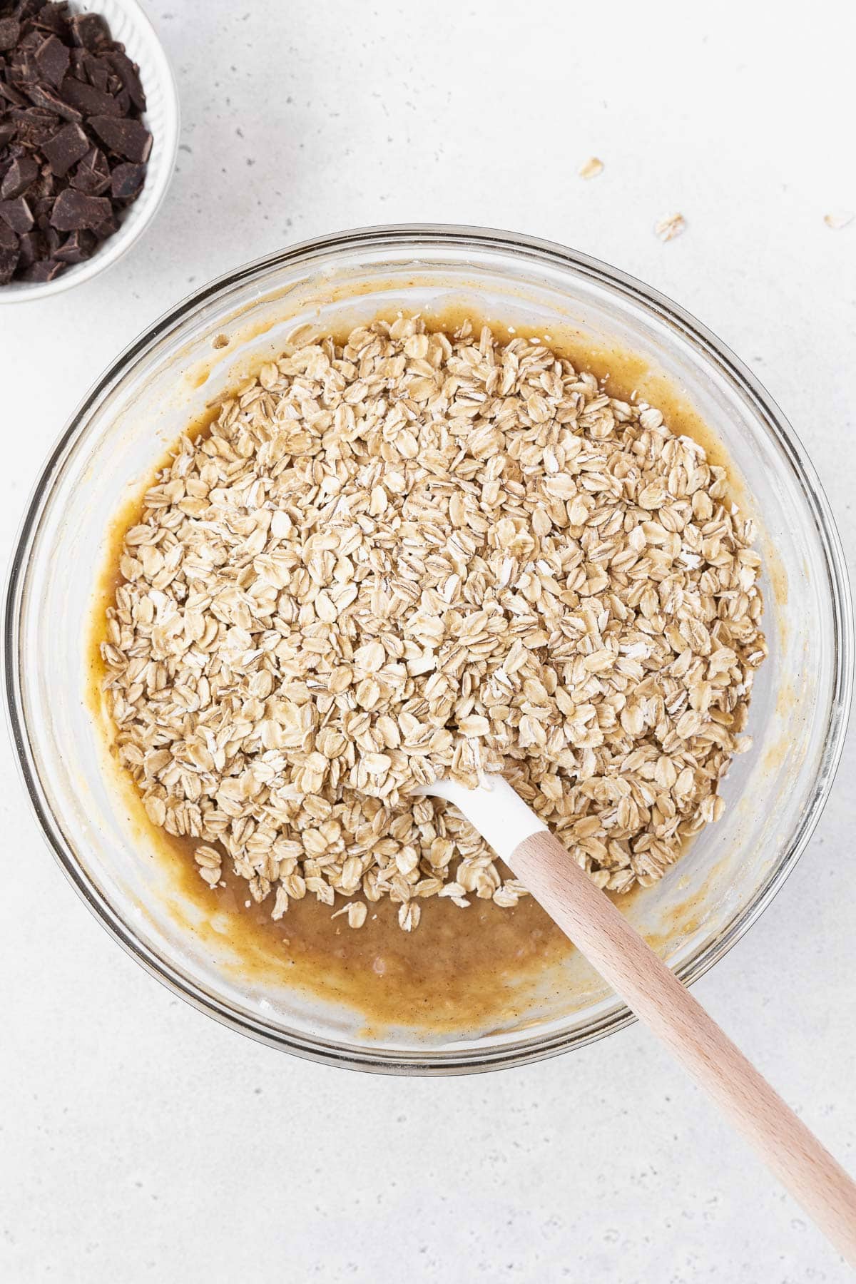 A mixing bowl of peanut butter banana bars with oatmeal on top.