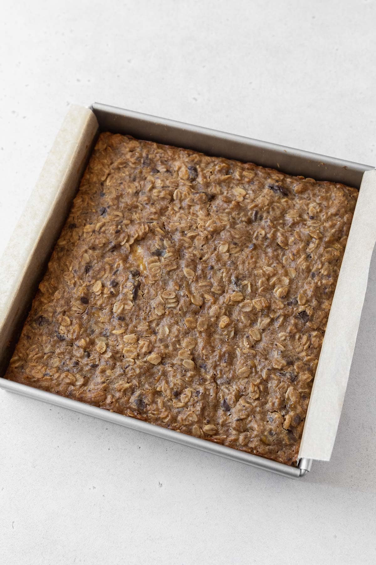 A baked pan of peanut butter banana oatmeal bars on the counter.