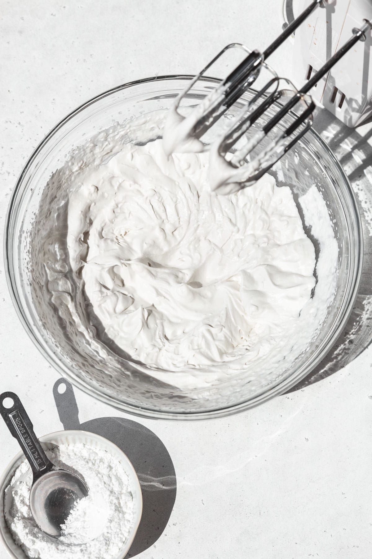 Vegan whipped cream in a mixing bowl after beating to stiff peaks.