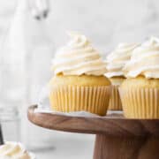 Square hero image of vegan vanilla cupcakes topped with a swirl of dairy-free vanilla buttercream.