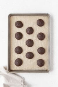 Baked whoopie pie cakes on a parchment paper lined baking sheet.
