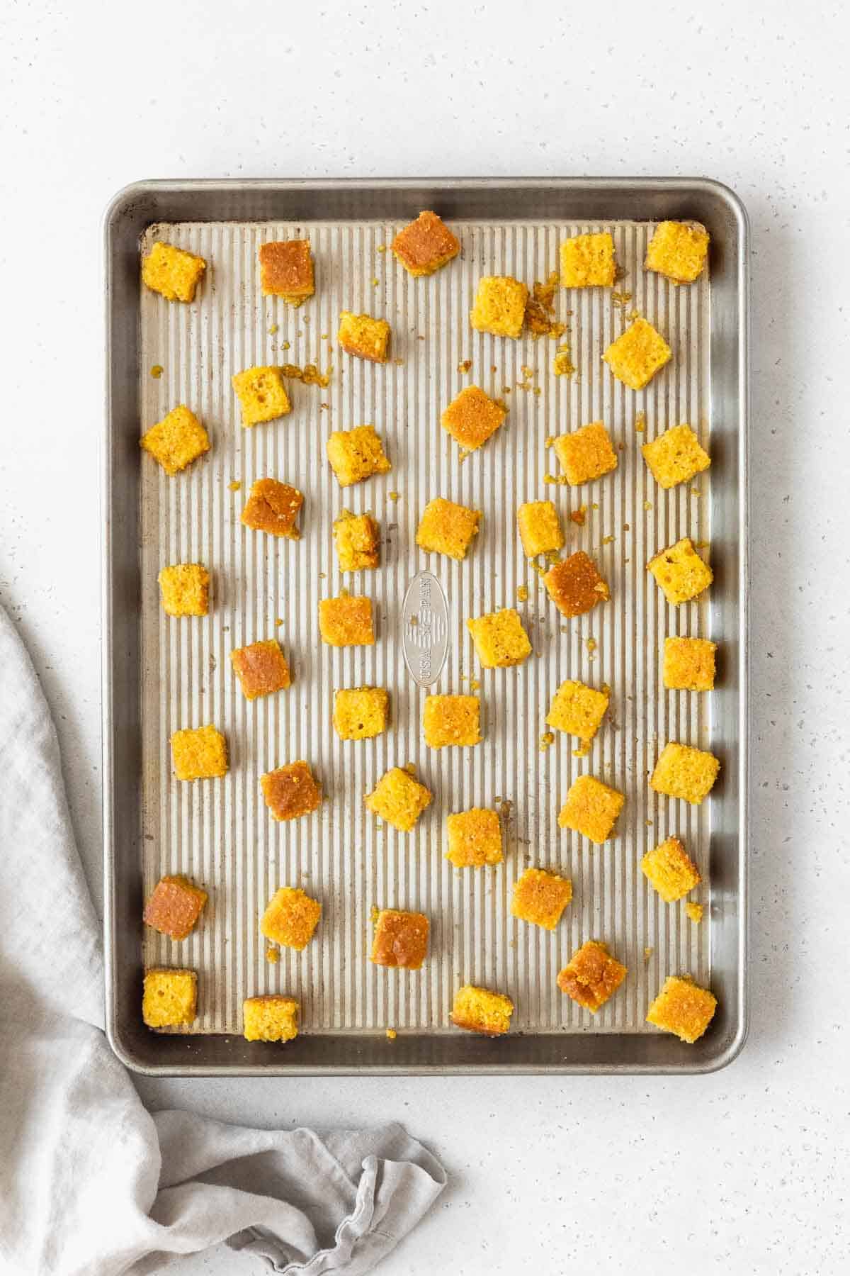 The cornbread croutons on a rimmed cookie sheet before baking.