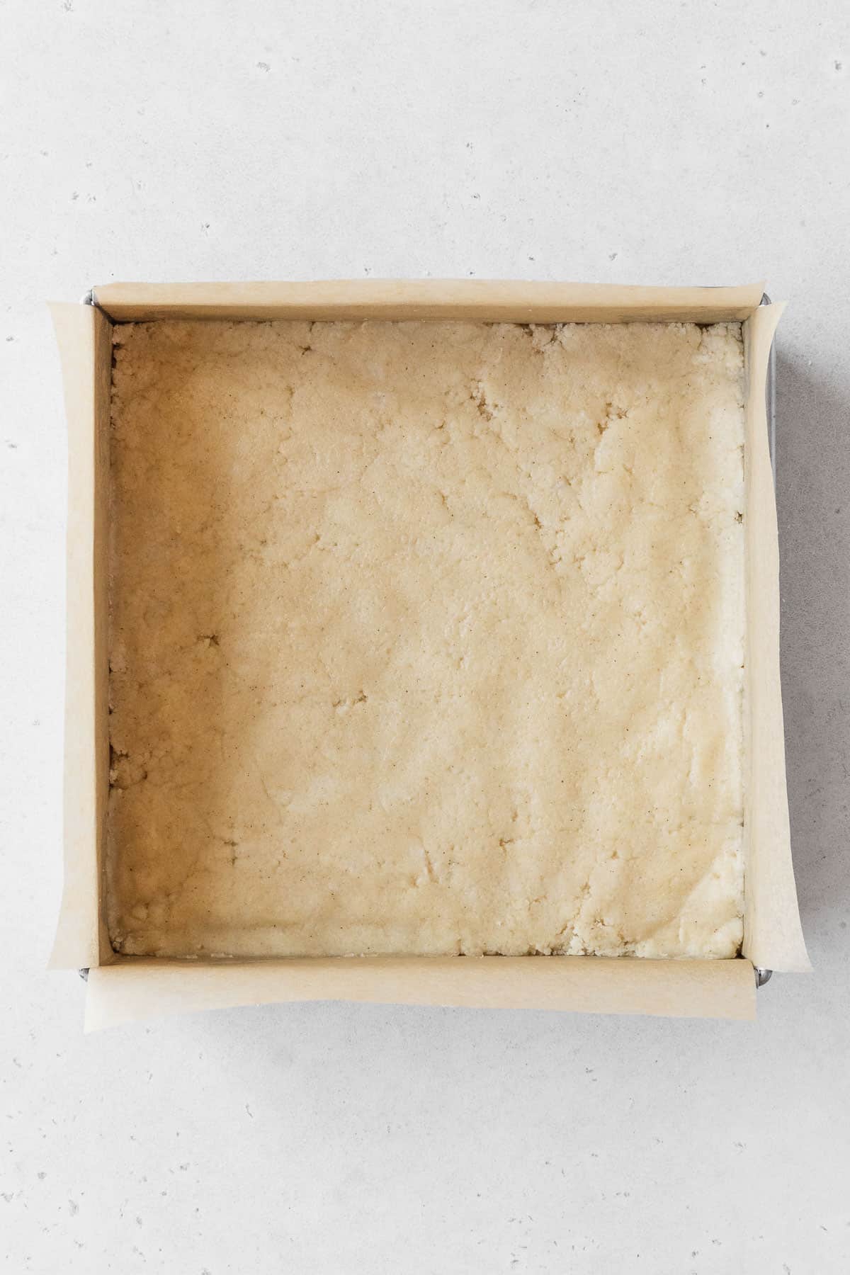 A metal baking pan of the dairy-free shortbread before baking.