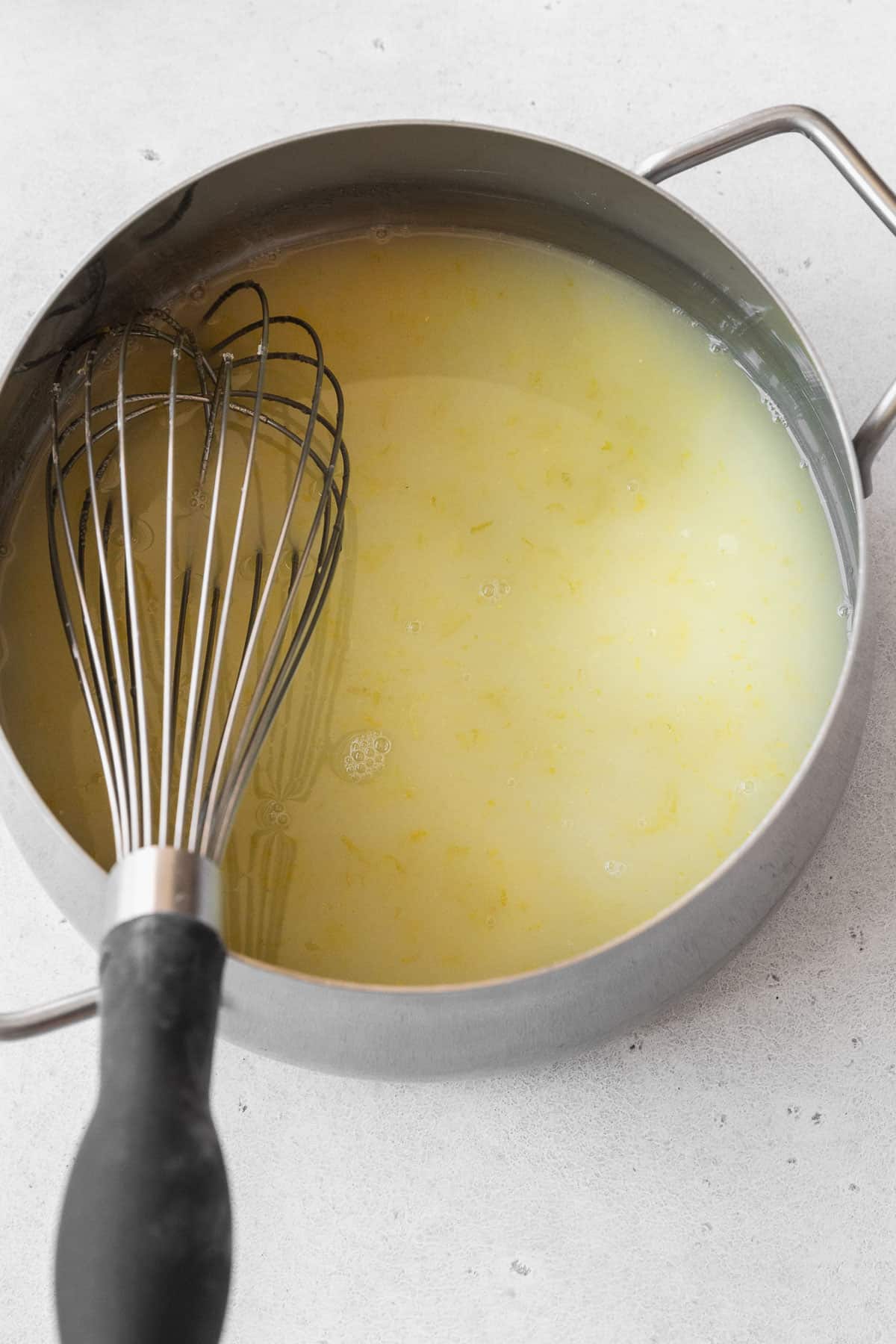 Whisked lemon juice, zest, and sugar in a pot.