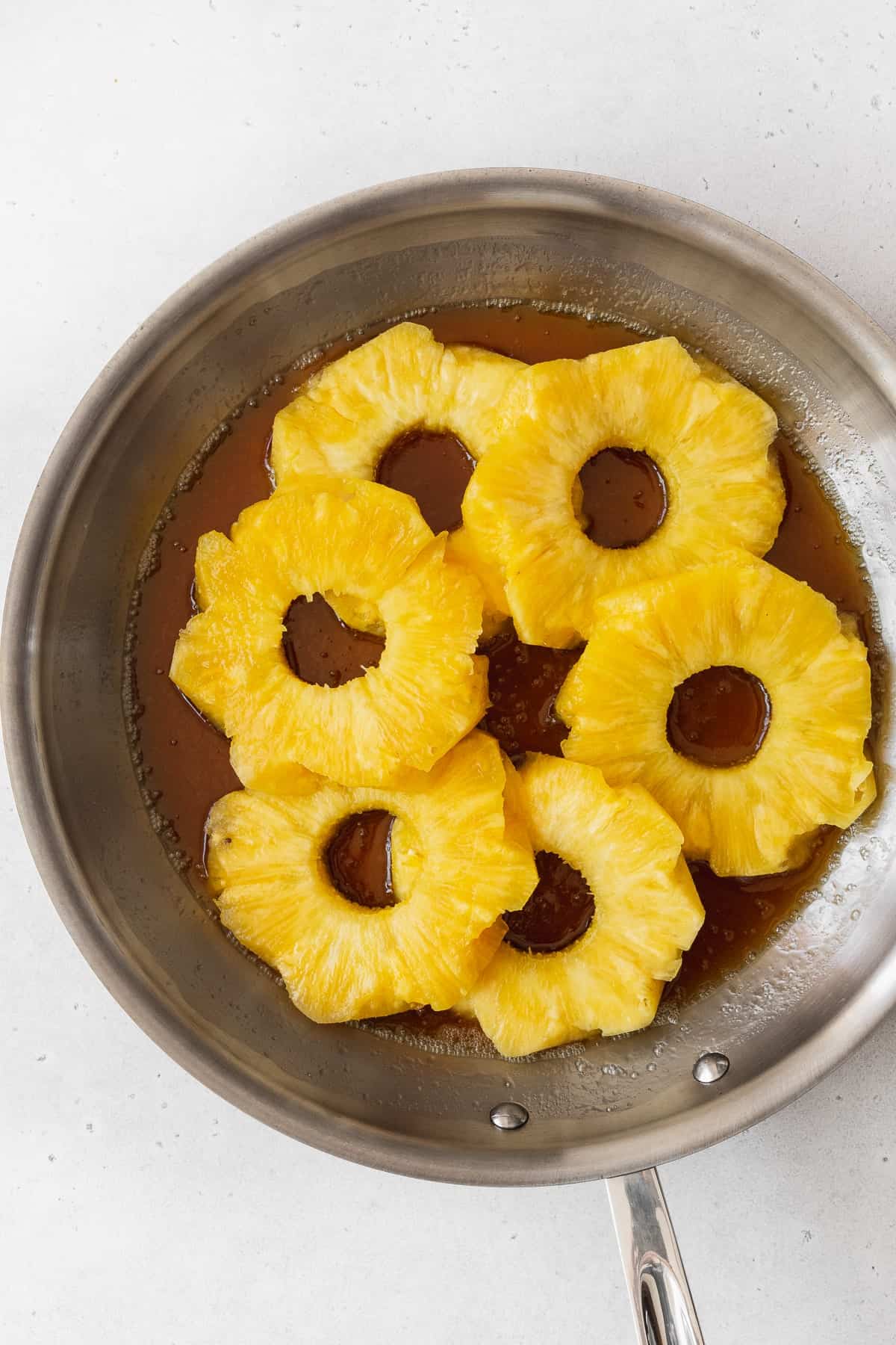 Cooking the brown sugar and pineapple in a skillet.