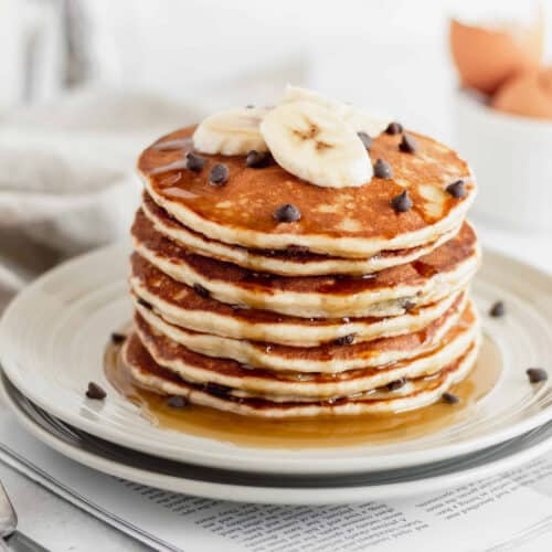 A stack of gluten free banana pancakes drizzled with maple syrup.